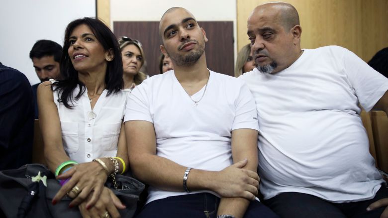 In this 2017 photo, Elor Azaria, flanked by his parents, sits inside a Israeli military court in Tel Aviv.